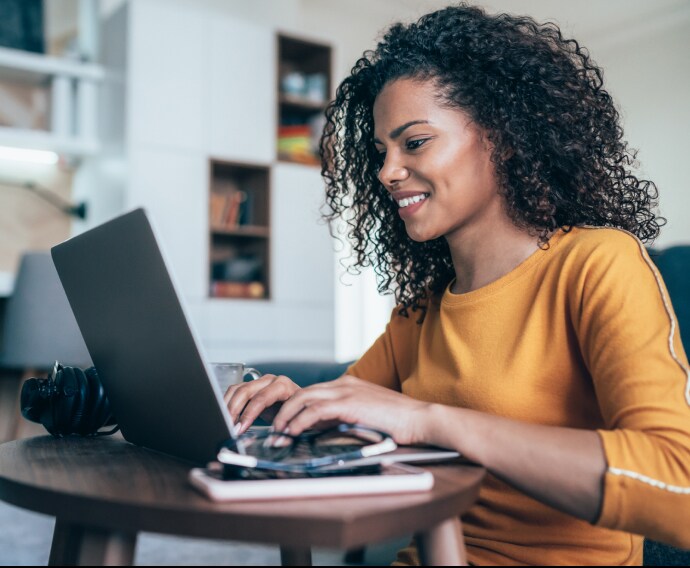 Kvinde arbejder hjemmefra med bærbar computer.